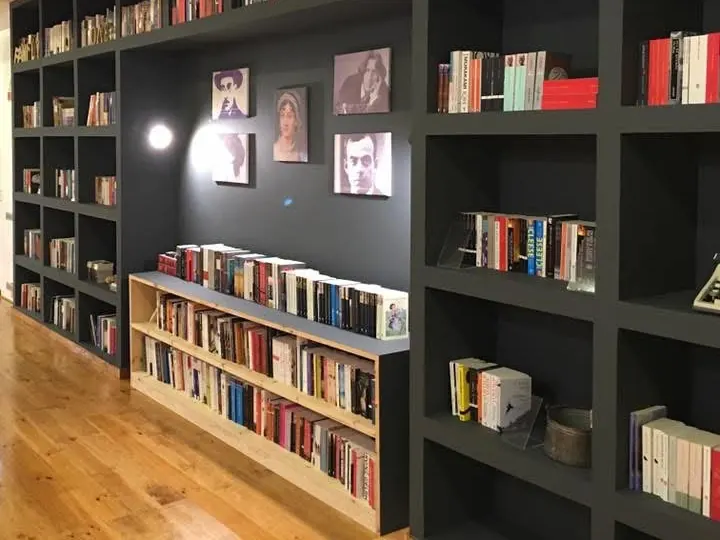Estantes escuras com livros e soalho de pinho na livraria, depois da obra.
