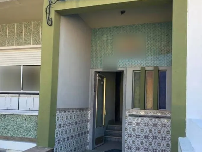 Entrada do prédio antes da obra, com pórtico antigo, parede em pastilha e azulejos antigos.